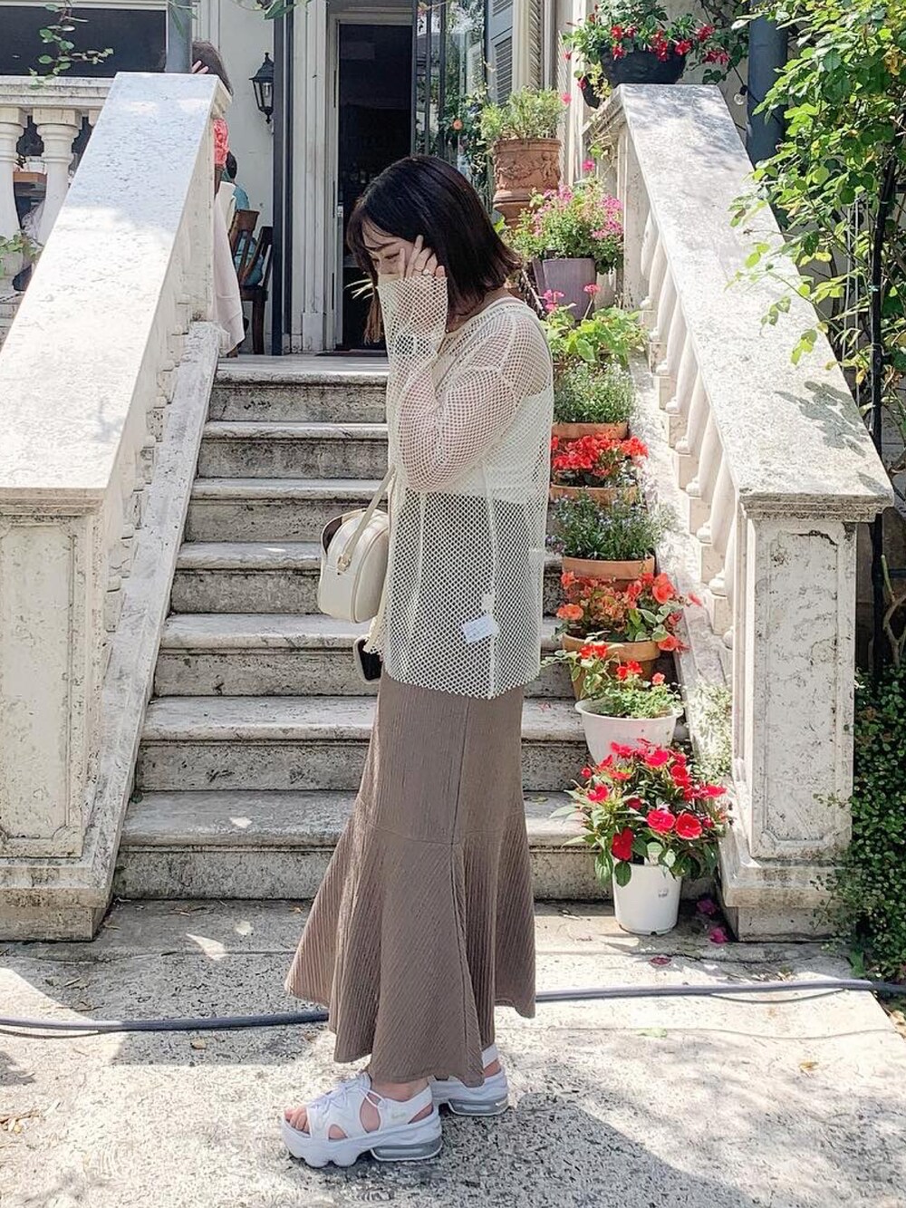 ホワイト系のサンダル、ブラウン系のスカート、ホワイト系のTシャツ/カットソーを着用したレディースの夏コーディネートの2枚目の写真