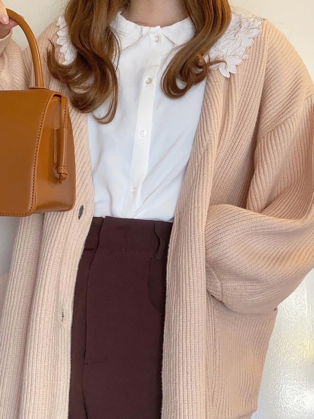 ピンク系のカーディガン/ボレロ、ブラック系のスラックス、ホワイト系のシャツ/ブラウスを着用したレディースの冬コーディネートの2枚目の写真