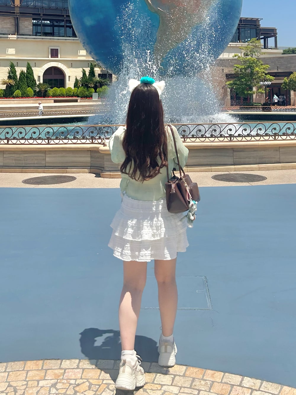 グリーン系のシャツ/ブラウス、ベージュ系のスニーカー、ホワイト系のスカートを着用したレディースの夏コーディネートの2枚目の写真