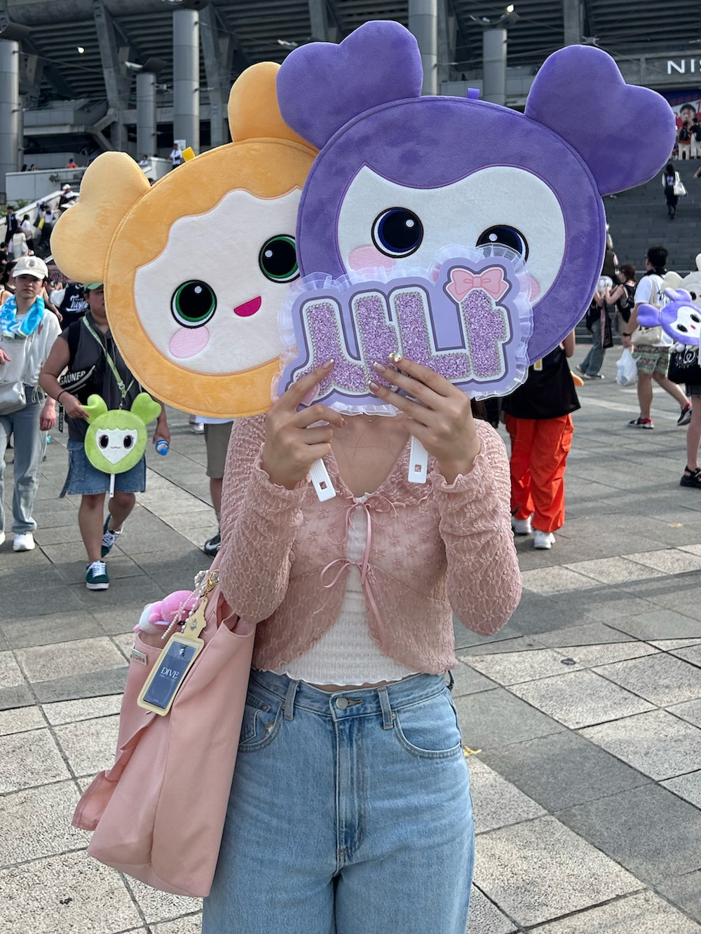 ブルー系のデニムパンツ、ピンク系のトートバッグ、ブラック系のスニーカーを着用したレディースの夏コーディネートの3枚目の写真