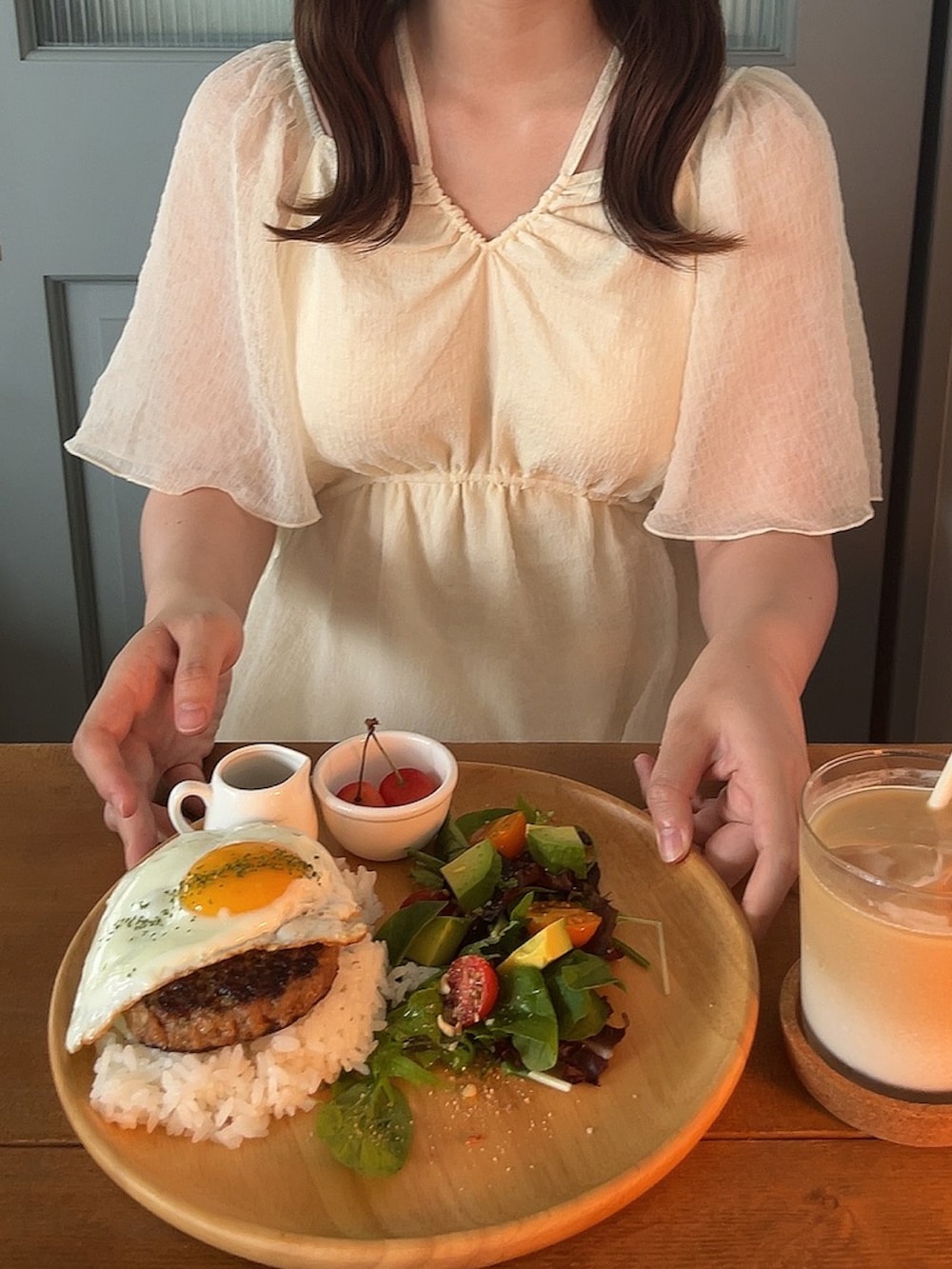 ホワイト系のワンピース、ベージュ系のサンダル、ホワイト系のハンドバッグを着用したレディースの夏コーディネートの2枚目の写真