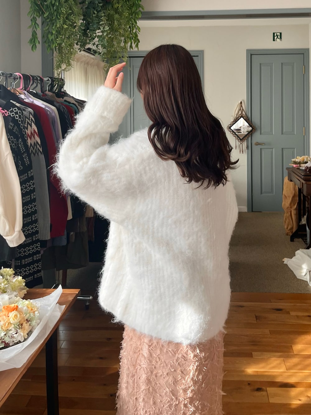 ピンク系のボストンバッグ、ピンク系のワンピース、ホワイト系のブーツを着用したレディースの冬コーディネートの2枚目の写真