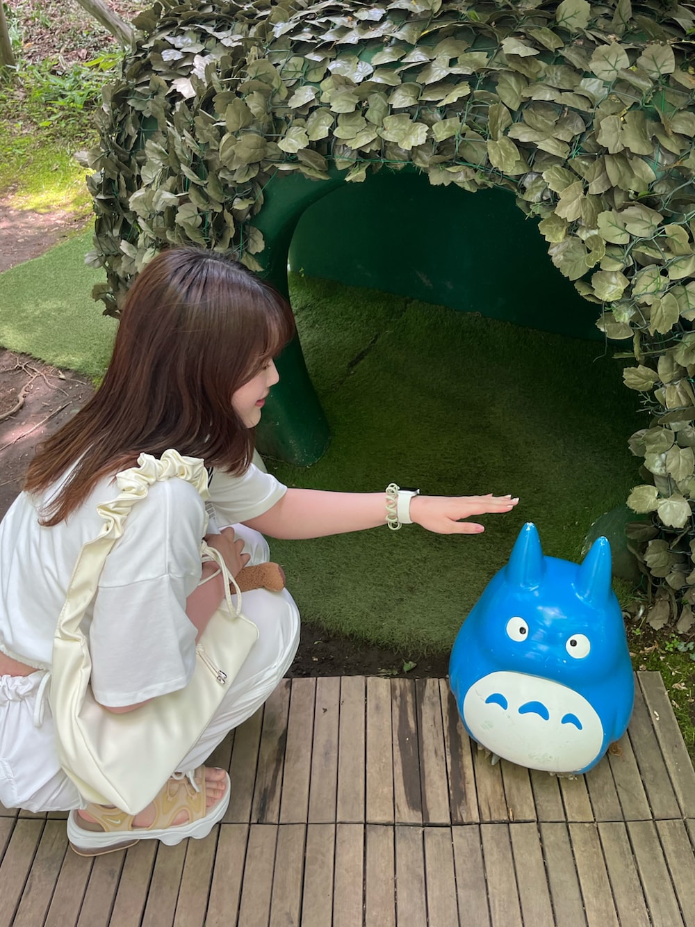 ホワイト系のカーゴパンツ、ホワイト系のハンドバッグ、ホワイト系のTシャツ/カットソーを着用したレディースの夏コーディネートの2枚目の写真