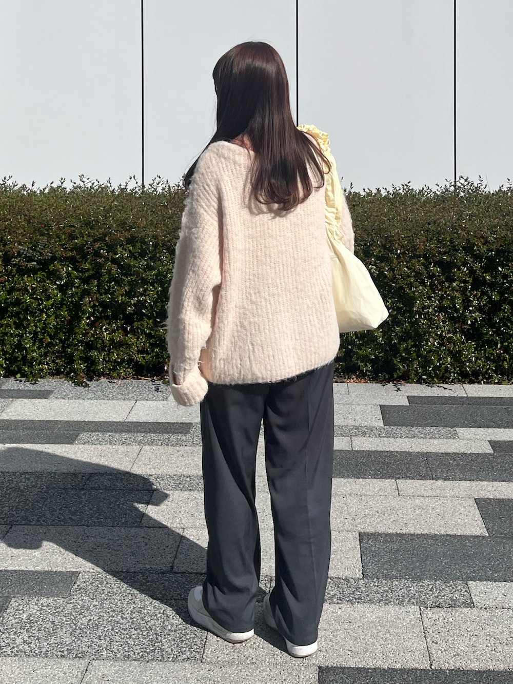 ピンク系のカーディガン/ボレロ、ホワイト系のスニーカー、ホワイト系のトートバッグを着用したレディースの春コーディネートの2枚目の写真