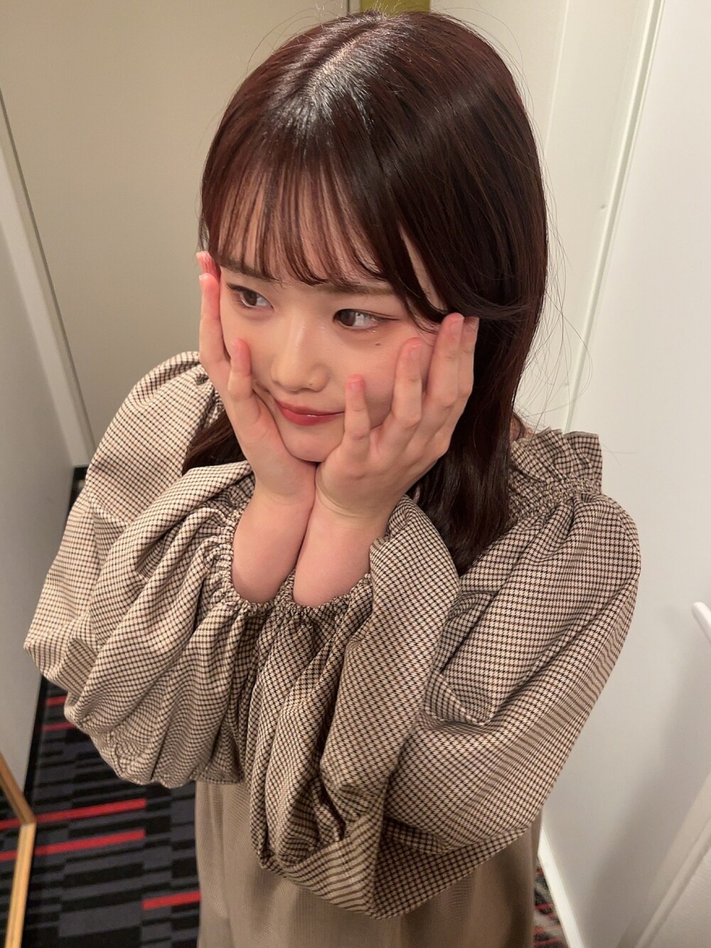 ベージュ系のボストンバッグ、ホワイト系のステンカラーコート、ブラウン系のブーツを着用したレディースの冬コーディネートの2枚目の写真