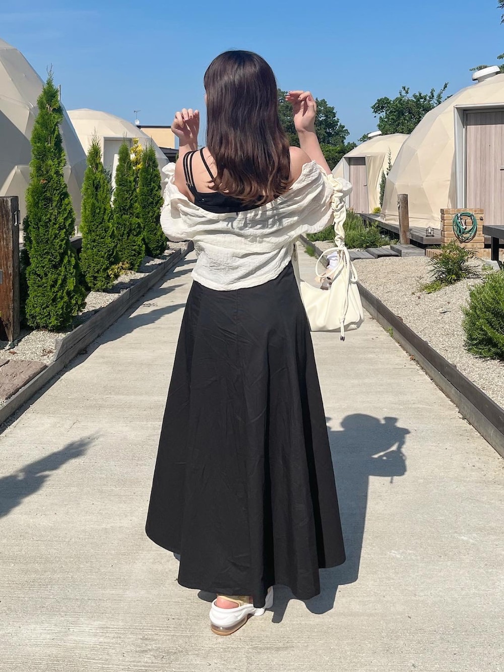 ブラック系のワンピース、ホワイト系のシャツ/ブラウス、ベージュ系のサンダルを着用したレディースの夏コーディネートの2枚目の写真