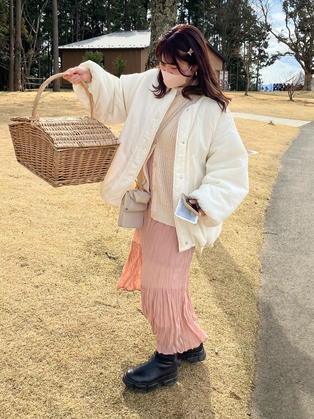 ホワイト系のカーディガン/ボレロ、ベージュ系のワンピース、ブラック系のブーツを着用したレディースの春コーディネートの3枚目の写真