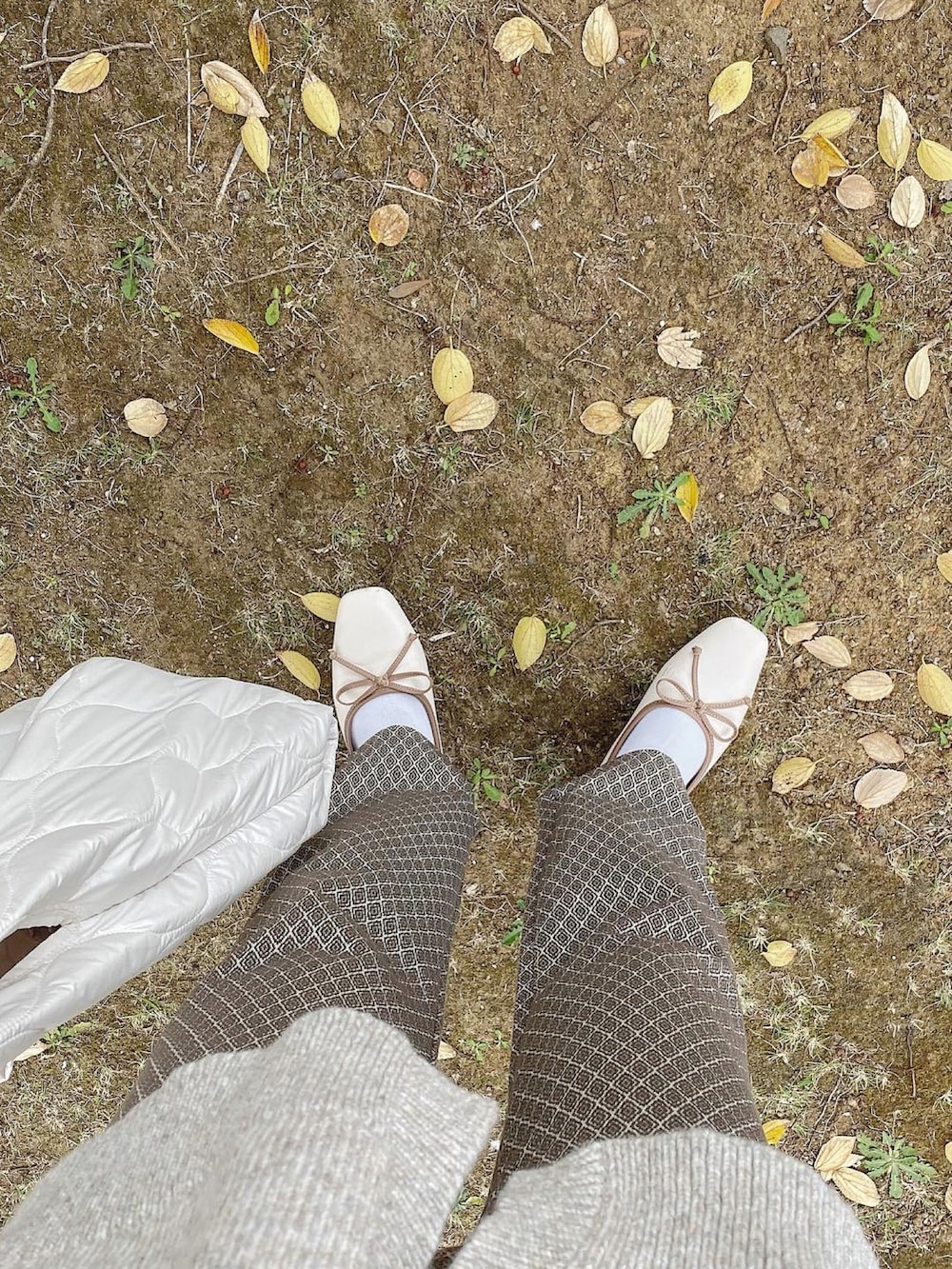 ベージュ系のニット/セーター、ブラウン系のその他パンツ、ホワイト系のトートバッグを着用したレディースの秋コーディネートの3枚目の写真