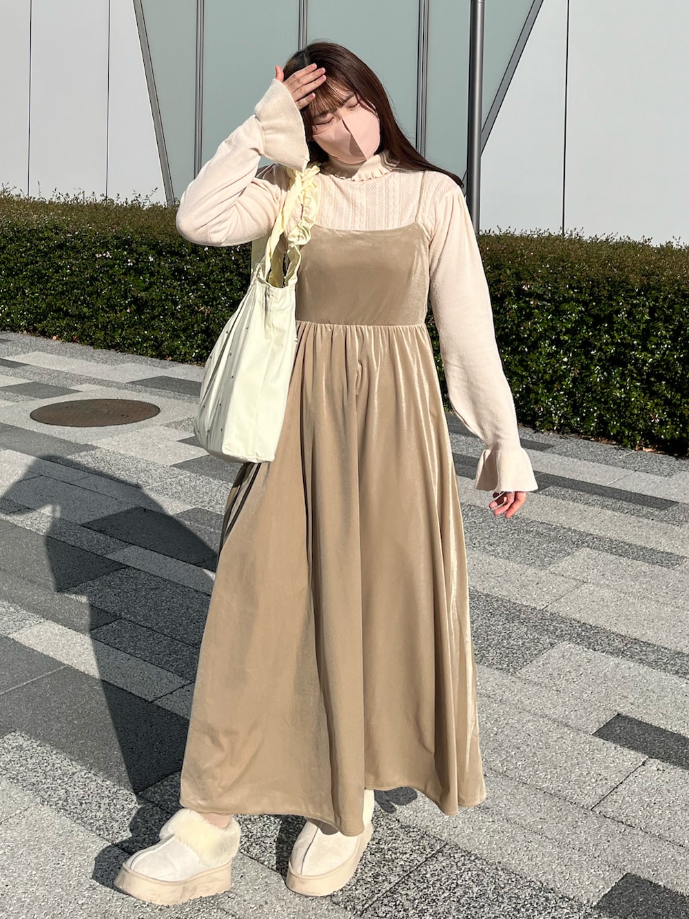 ホワイト系のブーツ、ブラウン系のその他アウター、ホワイト系のトートバッグを着用したレディースの冬コーディネートの3枚目の写真