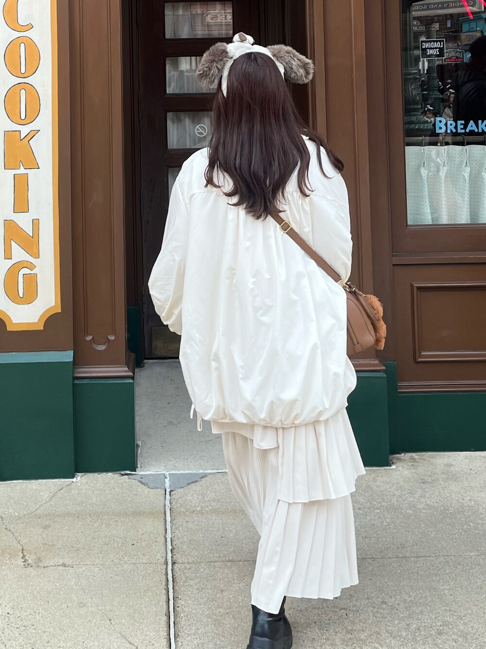 ブラック系のブーツ、ホワイト系のスカート、ホワイト系のブルゾンを着用したレディースの冬コーディネートの2枚目の写真