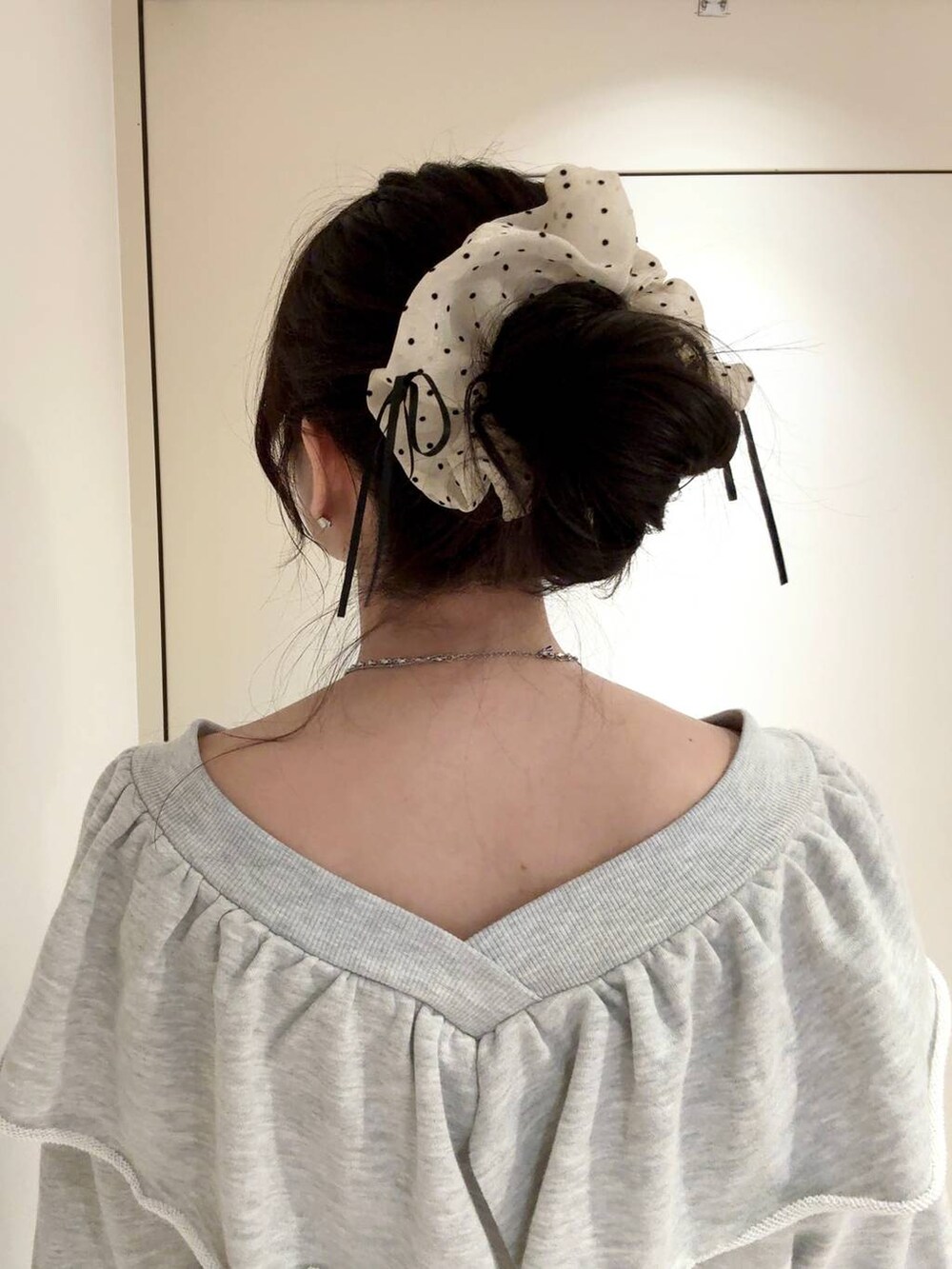 シルバー系のネックレス、ホワイト系のシュシュを着用したレディースの秋コーディネートの2枚目の写真