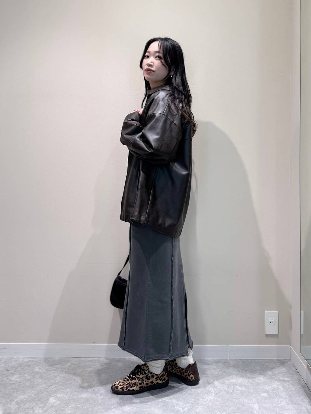 ブラック系のトートバッグ、グレー系のスカート、ブラウン系のブルゾンを着用したレディースの冬コーディネートの2枚目の写真