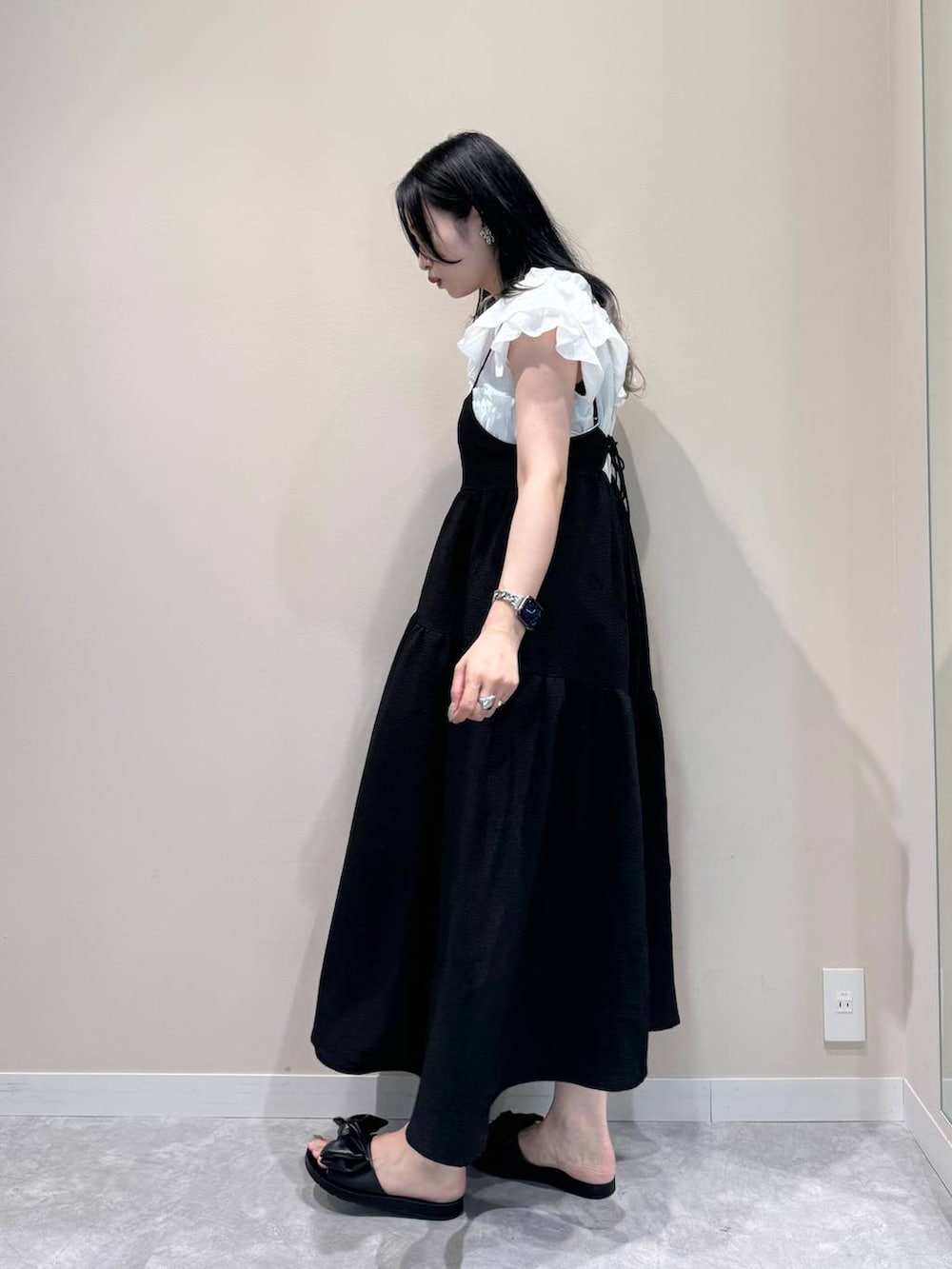 ブラック系のワンピース、ブラック系のショルダーバッグ、ブラック系のサンダルを着用したレディースの夏コーディネートの6枚目の写真