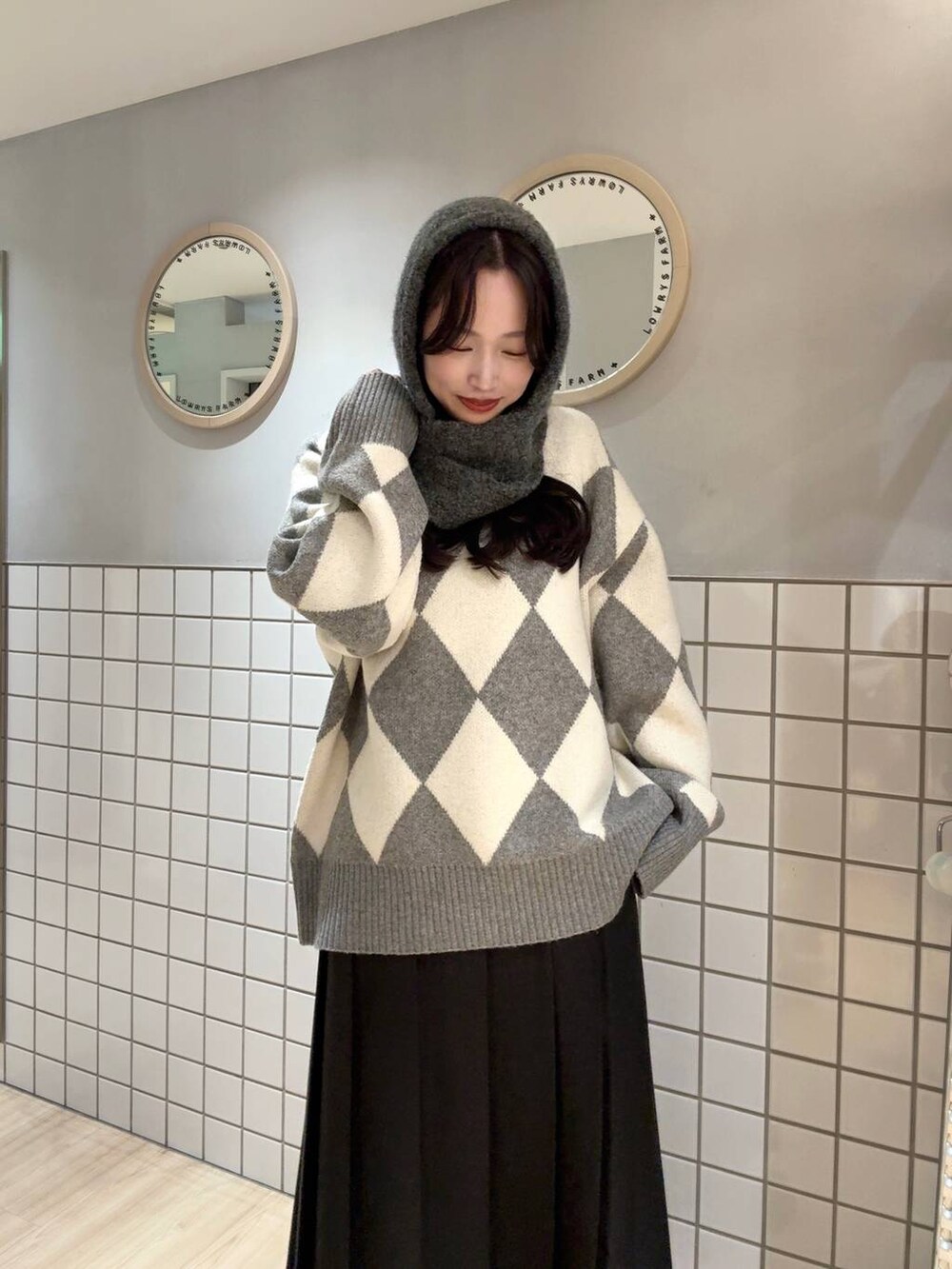 グレー系のニット/セーター、グレー系のマフラーを着用したレディースの秋コーディネートの3枚目の写真