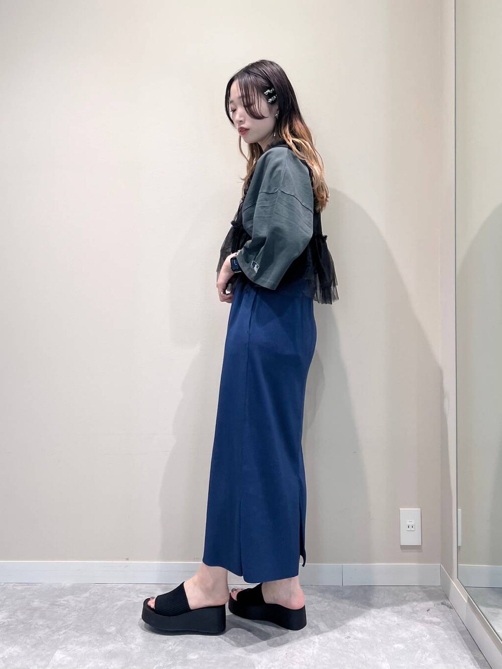 ブルー系のスカート、ブラック系のサンダル、グレー系のTシャツ/カットソーを着用したレディースの春コーディネートの2枚目の写真