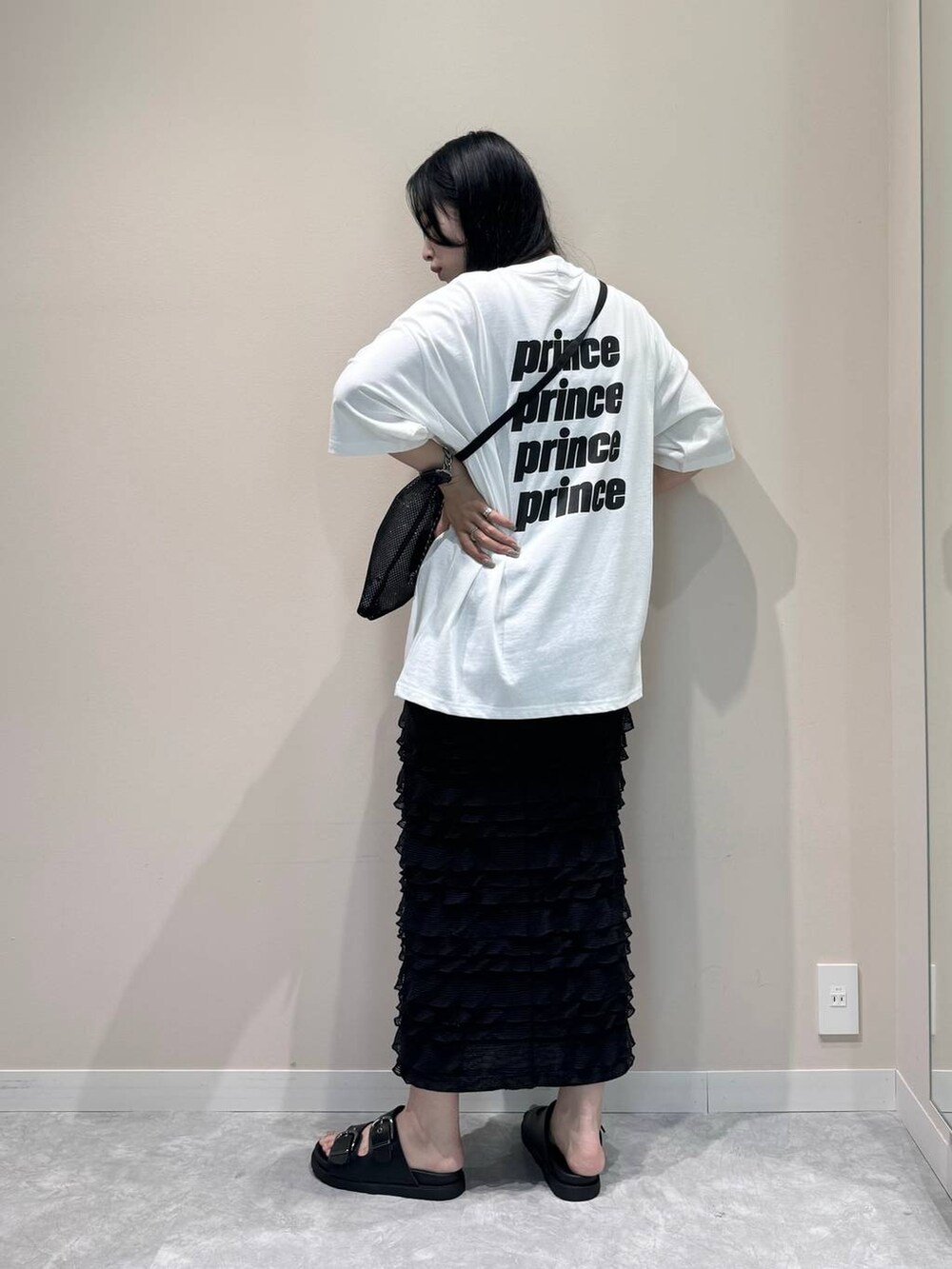 ブラック系のスカート、ブラック系のサンダル、ブラック系のショルダーバッグを着用したレディースの夏コーディネートの3枚目の写真