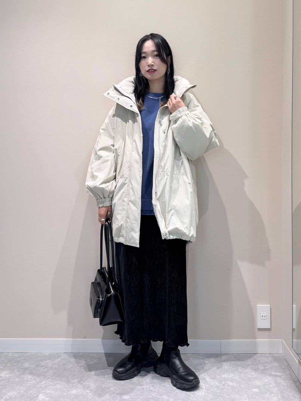 ホワイト系のその他アウター、ブルー系のニット/セーター、ブラック系のショルダーバッグを着用したレディースの冬コーディネートの2枚目の写真