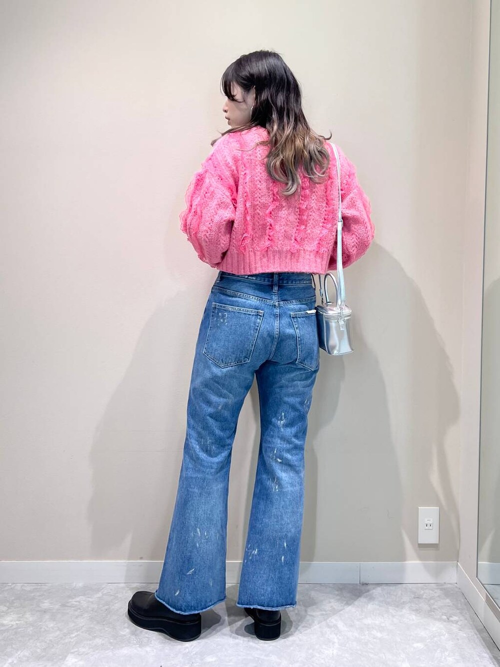 その他のデニムパンツ、ブラック系のブーツ、ピンク系のニット/セーターを着用したレディースの秋コーディネートの2枚目の写真