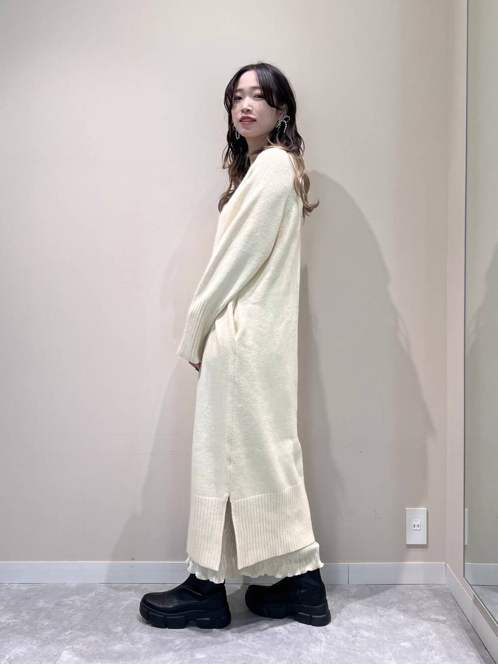 ブラック系のブーツ、ホワイト系のワンピース、ホワイト系のスカートを着用したレディースの冬コーディネートの2枚目の写真