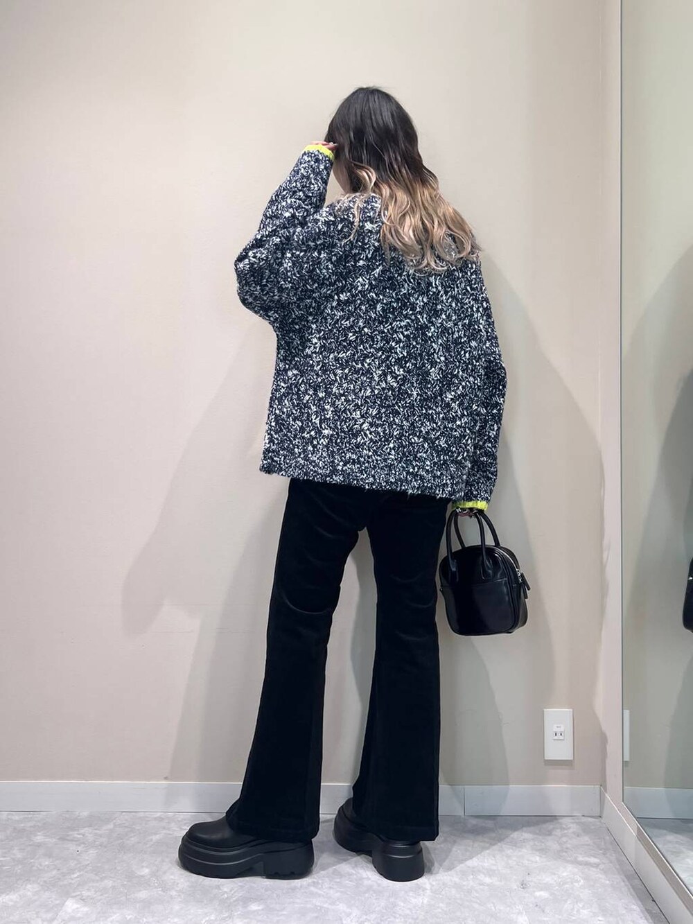 ブルー系のニット/セーター、ブラック系のブーツ、ブラック系のボストンバッグを着用したレディースの秋コーディネートの4枚目の写真