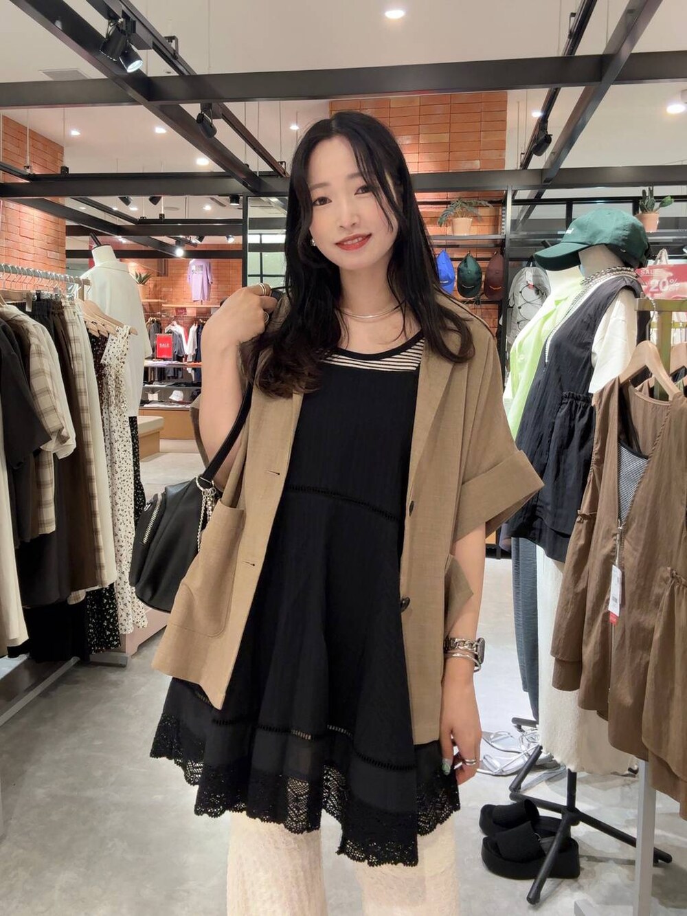 ブラック系のタンクトップ、ブラック系のサンダル、ホワイト系のその他パンツを着用したレディースの夏コーディネートの3枚目の写真