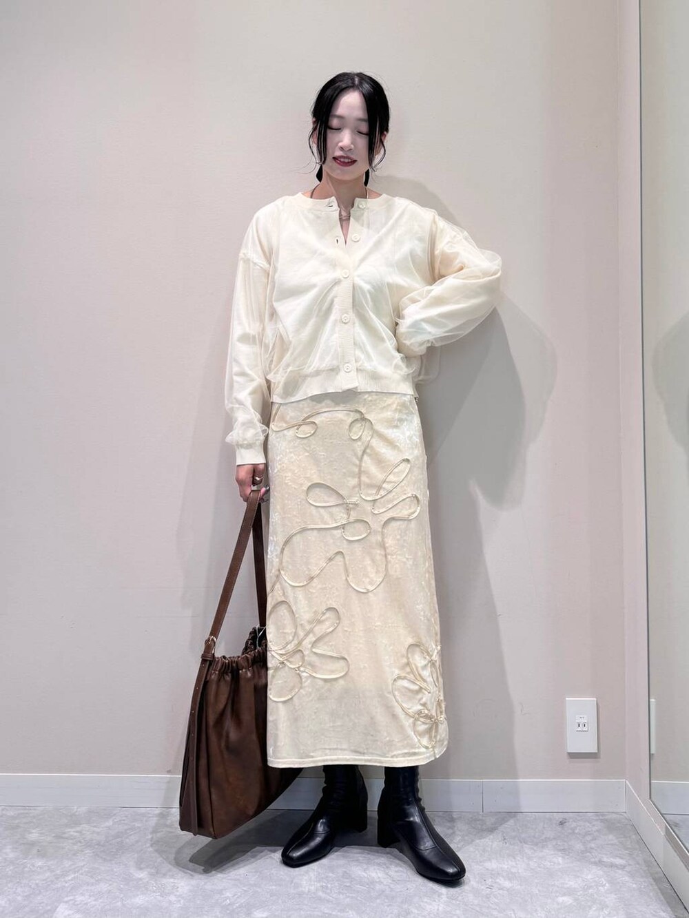 ホワイト系のニット/セーター、ブラック系のブーツ、ブラウン系のショルダーバッグを着用したレディースの秋コーディネートの3枚目の写真