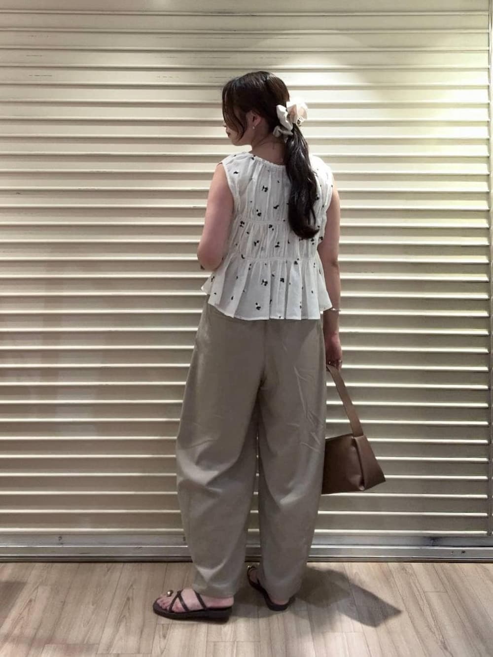 ベージュ系のその他パンツ、ブラウン系のショルダーバッグ、ブラウン系のサンダルを着用したレディースの夏コーディネートの2枚目の写真
