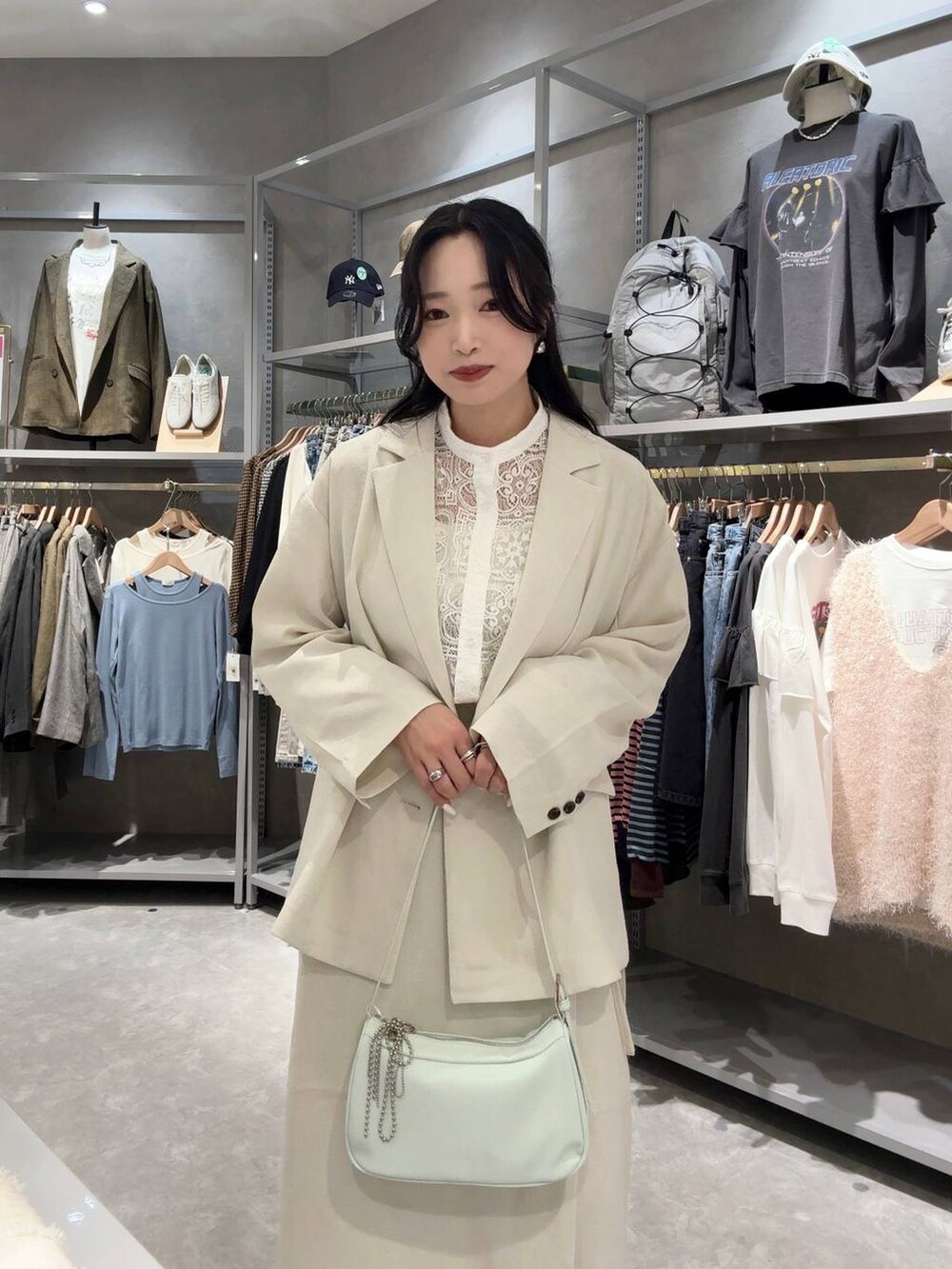 ホワイト系のスカート、ホワイト系のテーラードジャケット、グリーン系のトートバッグを着用したレディースの春コーディネートの4枚目の写真