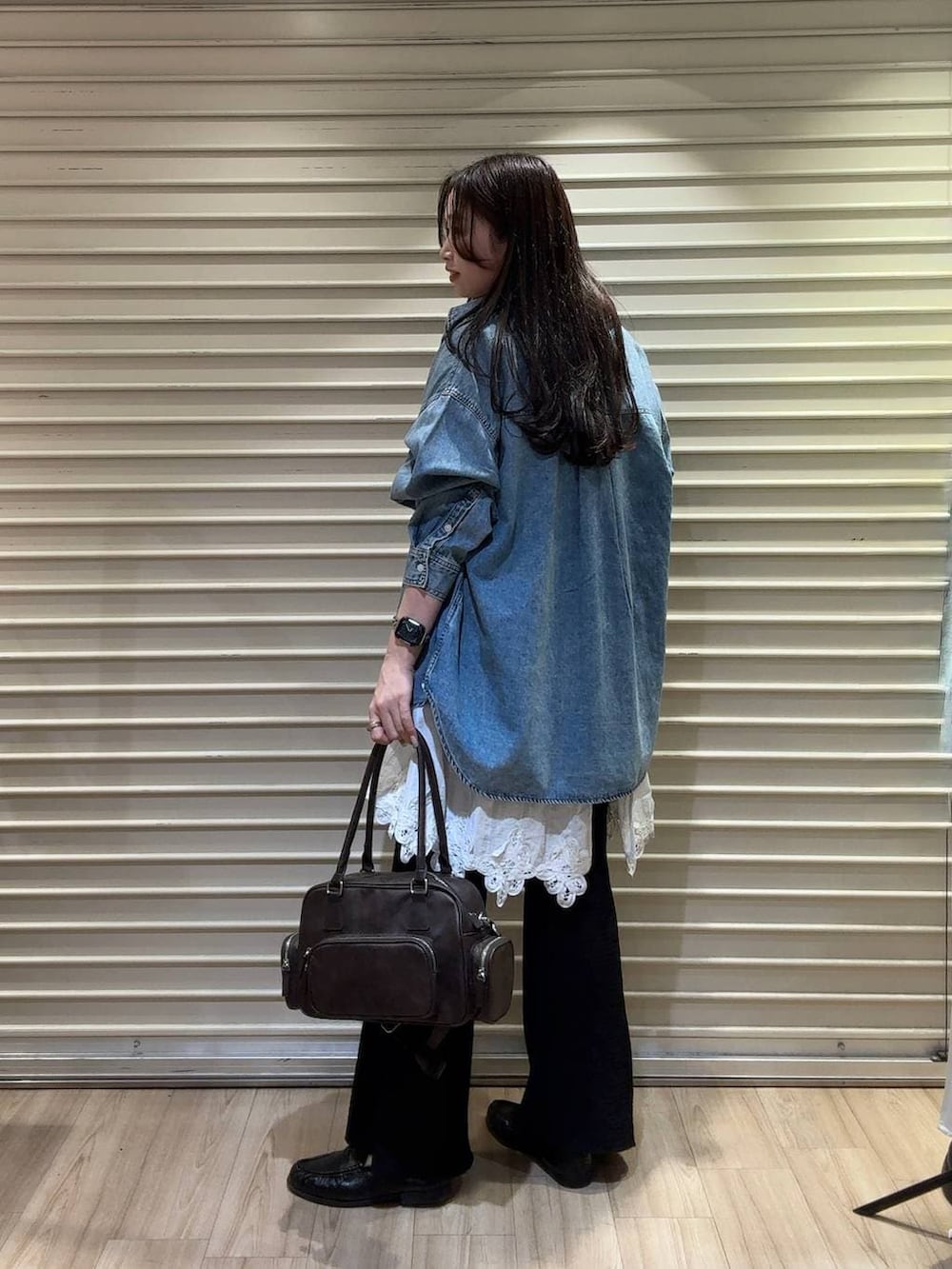 ブルー系のシャツ/ブラウス、ブラウン系のボストンバッグ、ブラック系のローファーを着用したレディースの春コーディネートの2枚目の写真