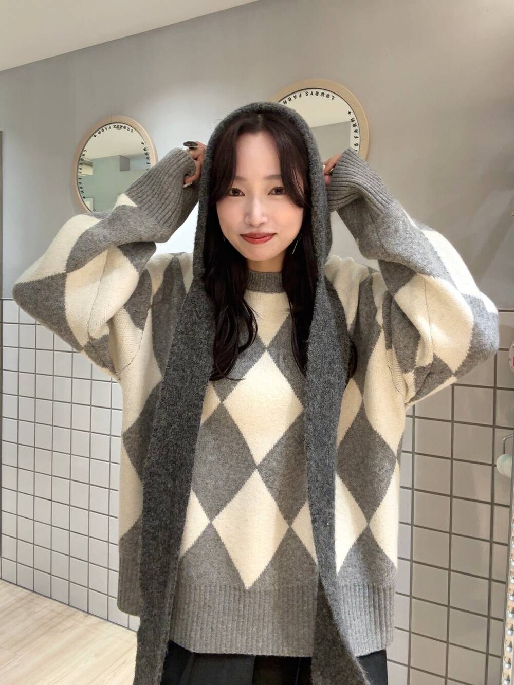 グレー系のニット/セーター、グレー系のマフラーを着用したレディースの秋コーディネートの4枚目の写真