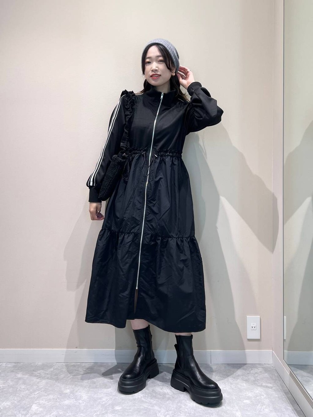 ブラック系のブーツ、ブラック系のショルダーバッグ、ブラック系のワンピースを着用したレディースの冬コーディネートの2枚目の写真