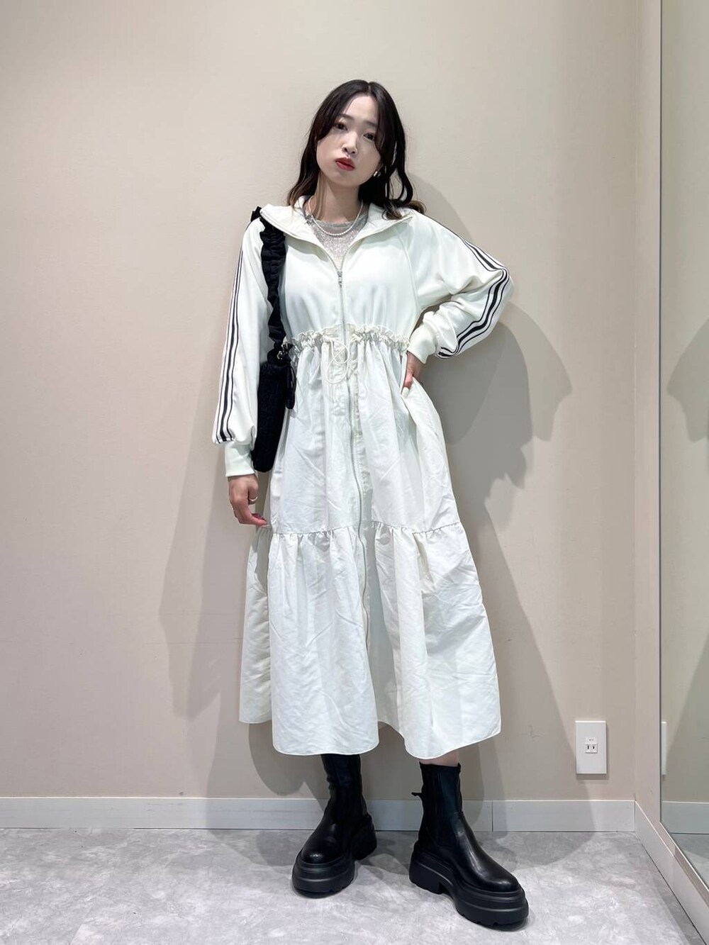 ブラック系のブーツ、ブラック系のショルダーバッグ、ホワイト系のTシャツ/カットソーを着用したレディースの冬コーディネートの2枚目の写真