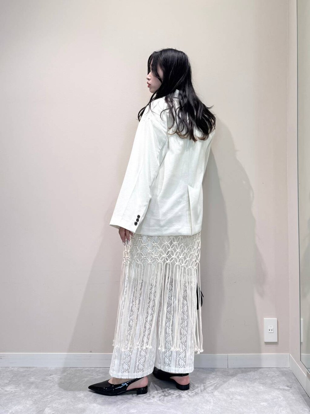 ホワイト系のテーラードジャケット、ホワイト系のTシャツ/カットソー、ブラック系のトートバッグを着用したレディースの春コーディネートの4枚目の写真