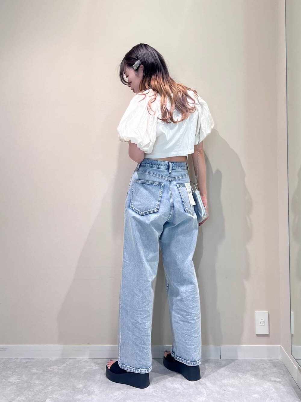 シルバー系のショルダーバッグ、ブラック系のサンダル、ホワイト系のTシャツ/カットソーを着用したレディースの夏コーディネートの2枚目の写真