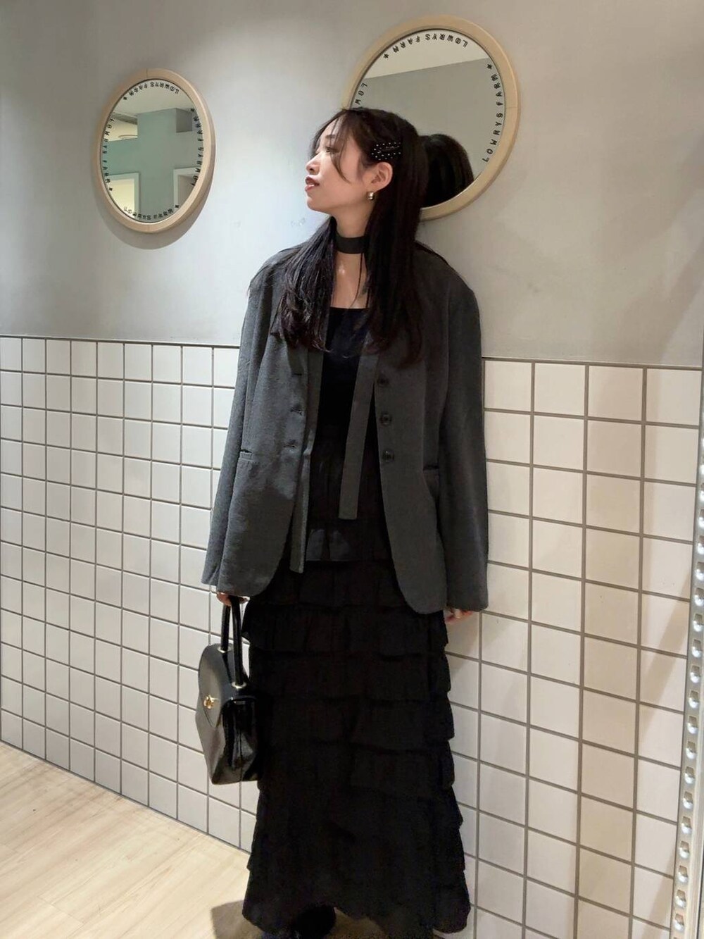 ブラック系のタンクトップ、グレー系のテーラードジャケット、ブラック系のボストンバッグを着用したレディースの秋コーディネートの2枚目の写真