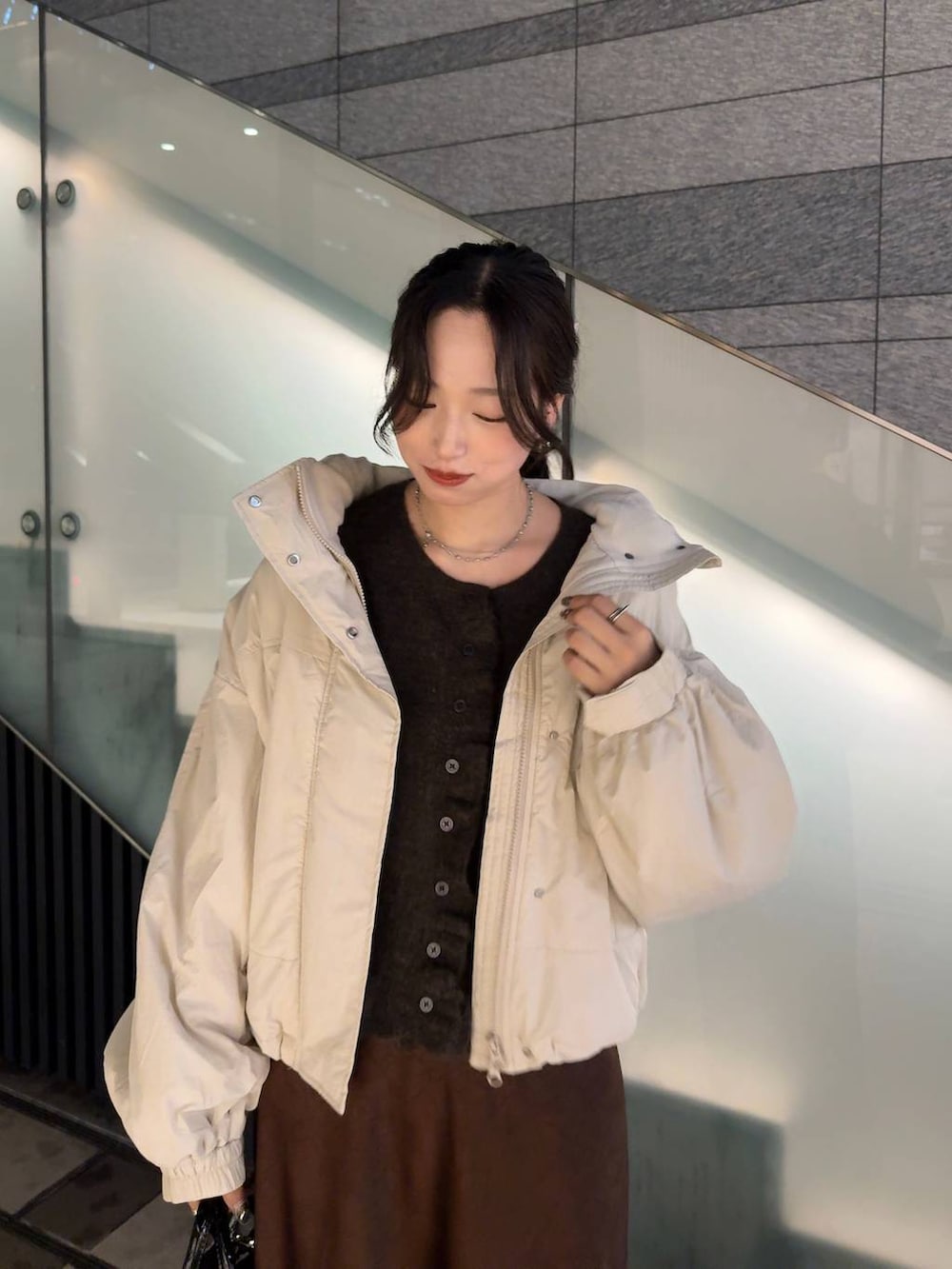 ホワイト系のその他アウター、ブラウン系のスカート、ブラウン系のニット/セーターを着用したレディースの秋コーディネートの2枚目の写真