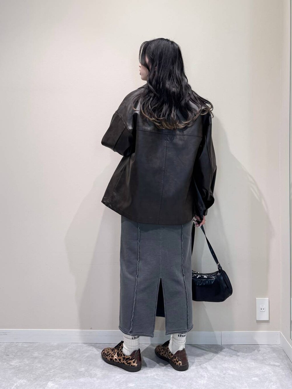 ブラック系のトートバッグ、グレー系のスカート、ブラウン系のブルゾンを着用したレディースの冬コーディネートの3枚目の写真