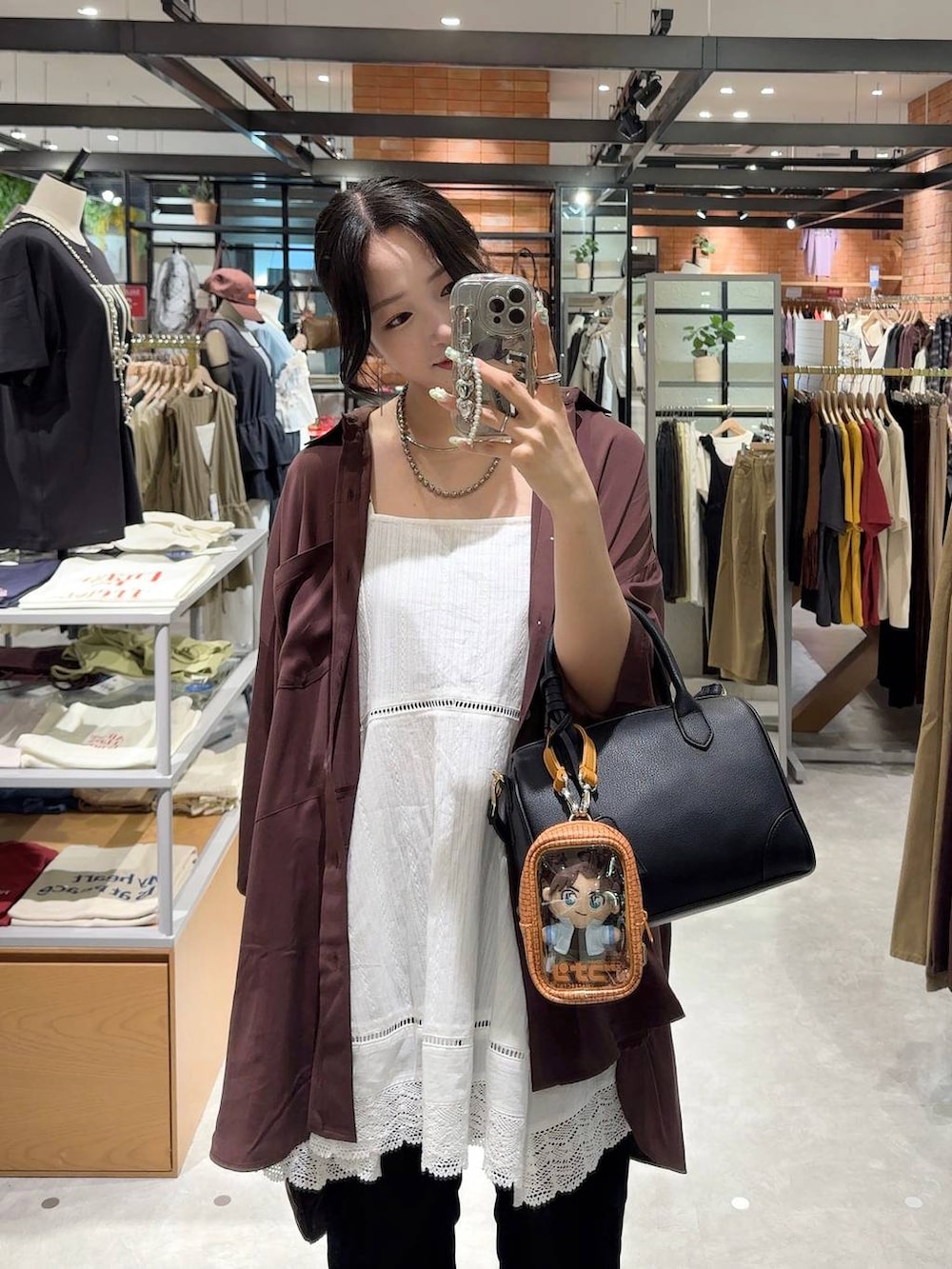 ホワイト系のワンピース、ブラック系のショルダーバッグ、ブラック系のその他パンツを着用したレディースの夏コーディネートの2枚目の写真