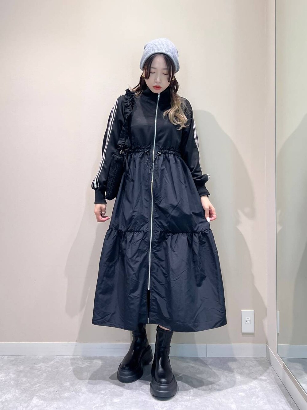 ブラック系のブーツ、ブラック系のショルダーバッグ、ブラック系のワンピースを着用したレディースの冬コーディネートの3枚目の写真