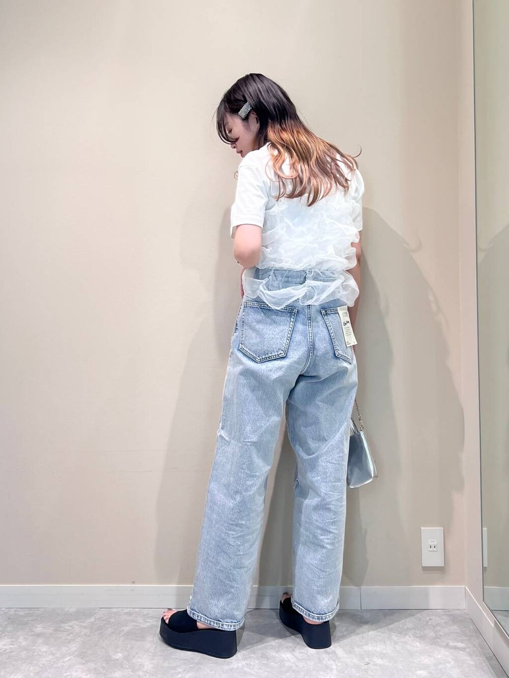 シルバー系のショルダーバッグ、ブルー系のデニムパンツ、ホワイト系のTシャツ/カットソーを着用したレディースの夏コーディネートの2枚目の写真