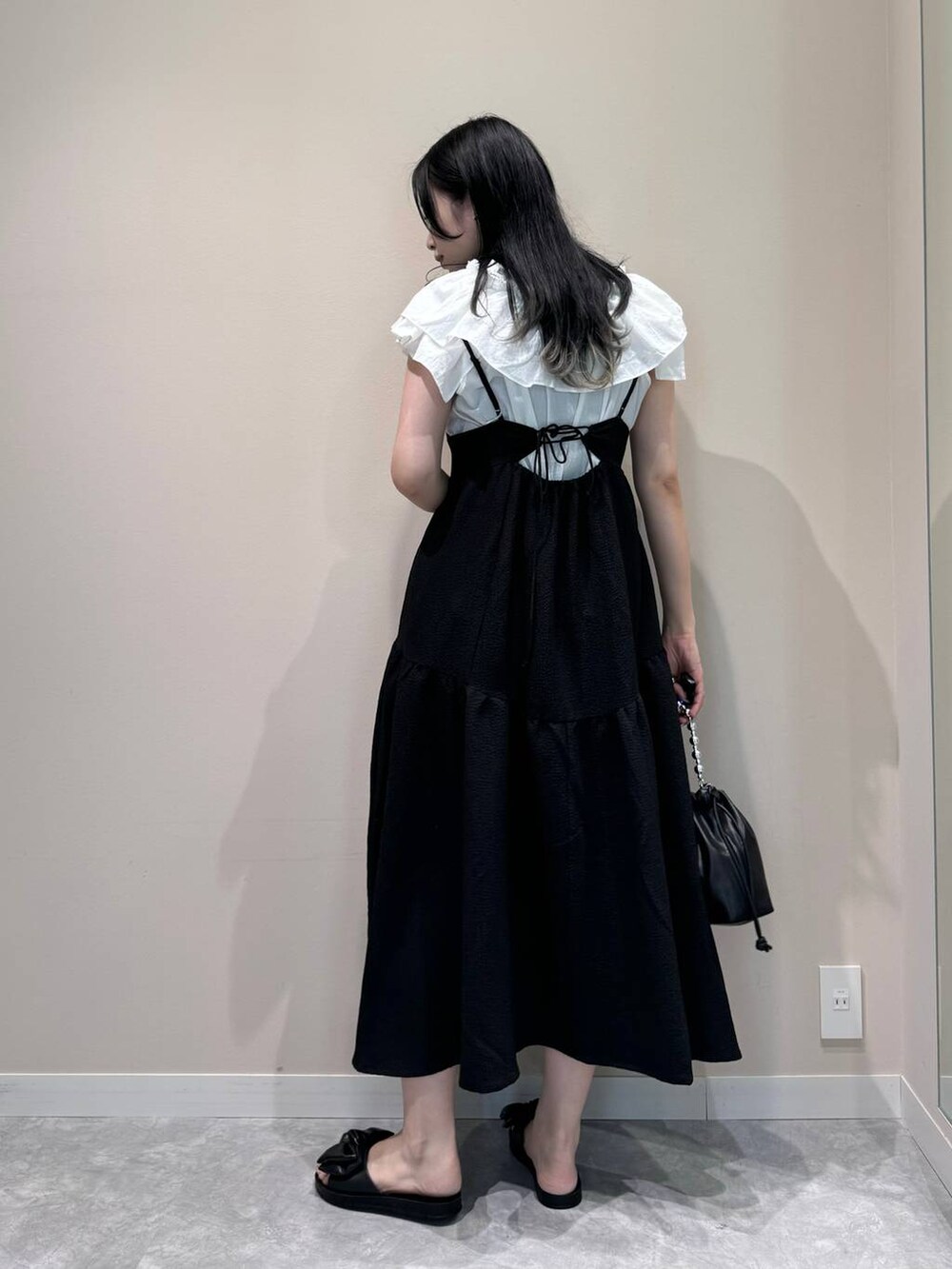 ブラック系のワンピース、ブラック系のショルダーバッグ、ブラック系のサンダルを着用したレディースの夏コーディネートの4枚目の写真