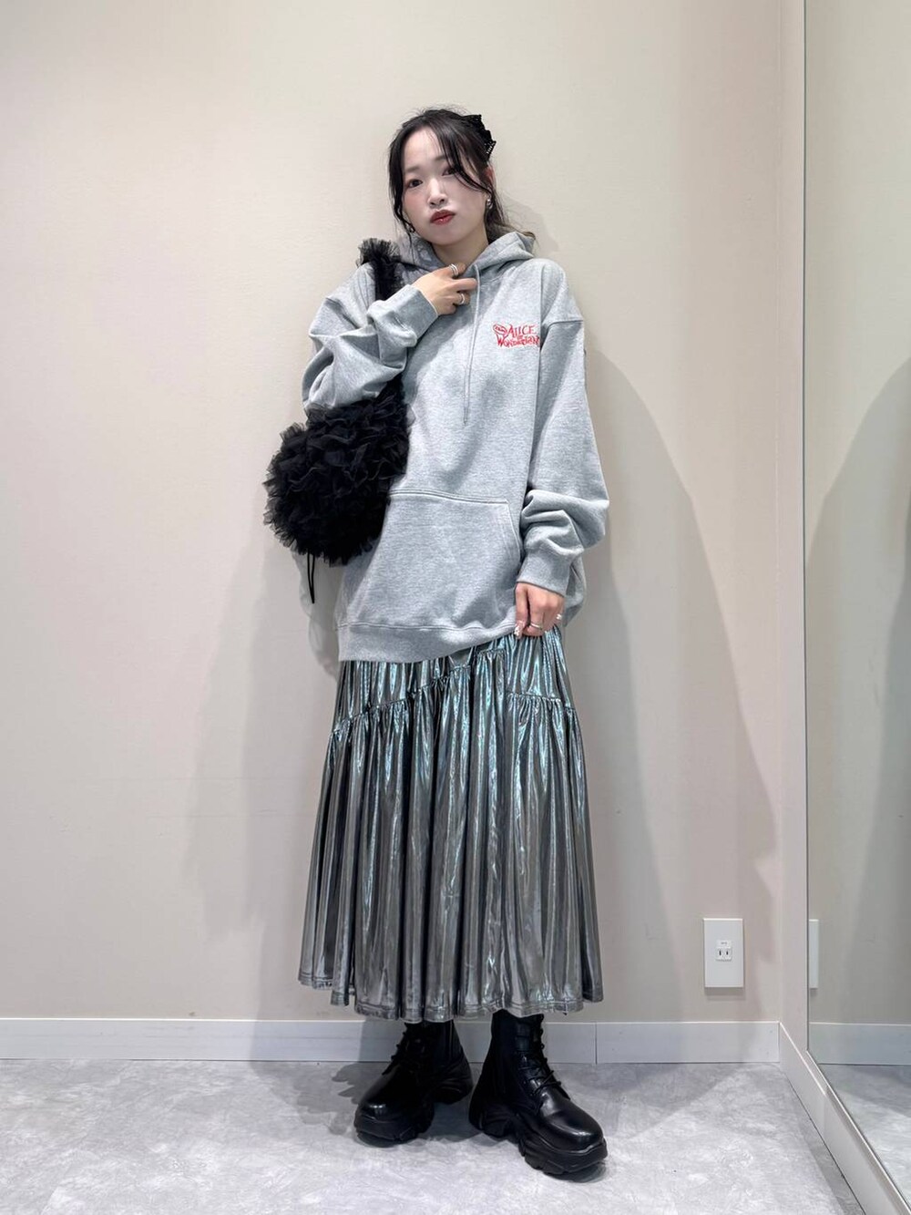 グレー系のスカート、グレー系のスウェット、ブラック系のショルダーバッグを着用したレディースの秋コーディネートの2枚目の写真