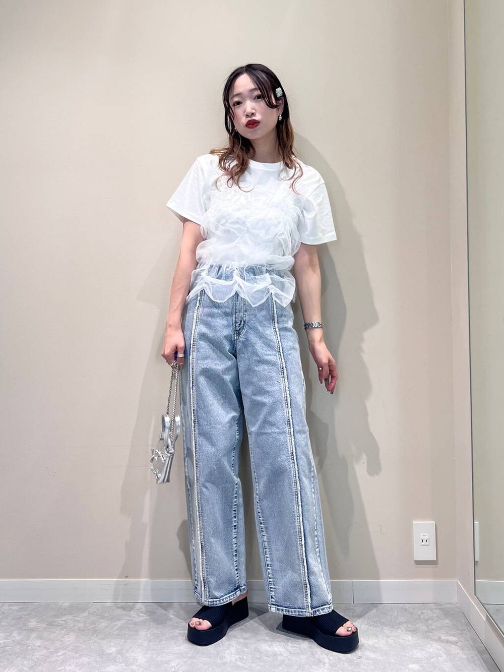 シルバー系のショルダーバッグ、ブルー系のデニムパンツ、ホワイト系のTシャツ/カットソーを着用したレディースの夏コーディネートの4枚目の写真