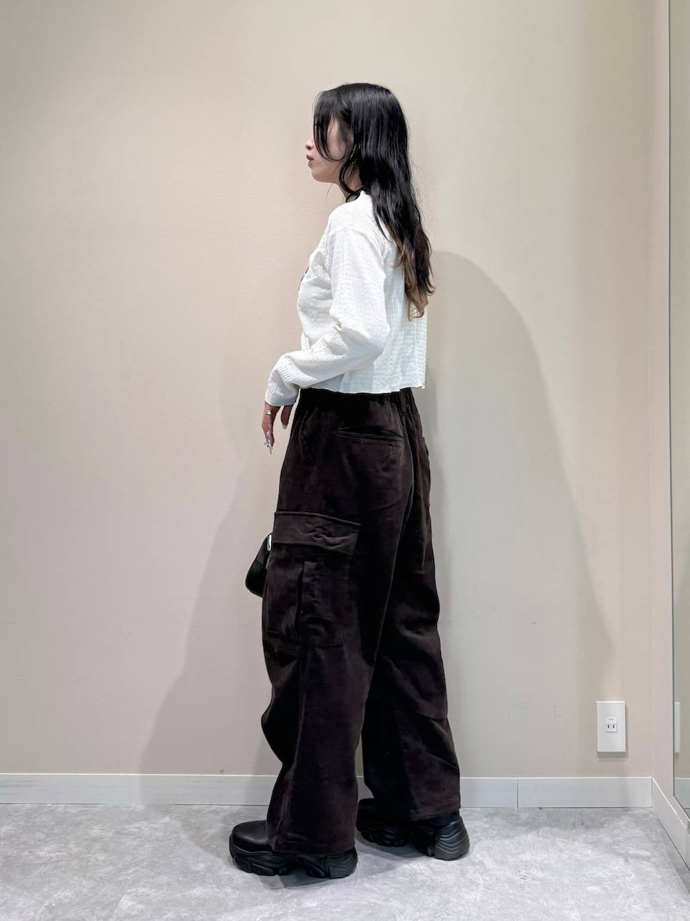 ブラック系のブーツ、ブラック系のボストンバッグ、ブラウン系のカーゴパンツを着用したレディースの秋コーディネートの3枚目の写真