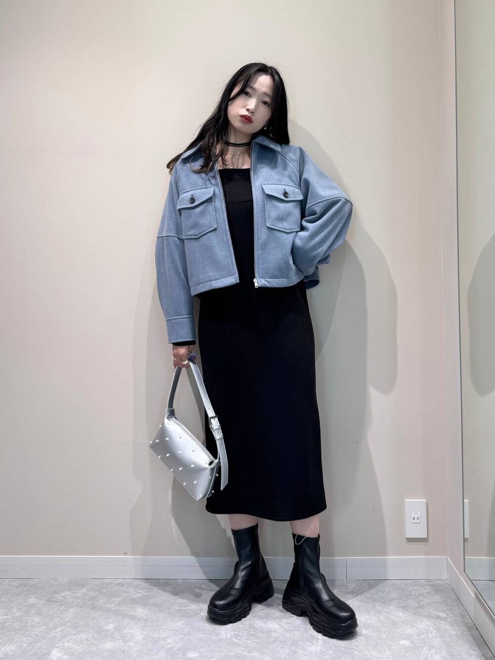 ブラック系のブーツ、シルバー系のショルダーバッグ、ブラック系のワンピースを着用したレディースの冬コーディネートの5枚目の写真