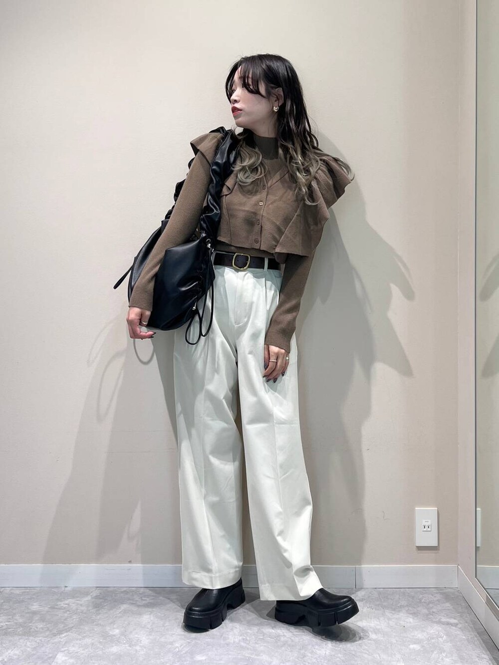 ブラック系のショルダーバッグ、ブラック系のブーツ、ブラウン系のニット/セーターを着用したレディースの冬コーディネートの3枚目の写真