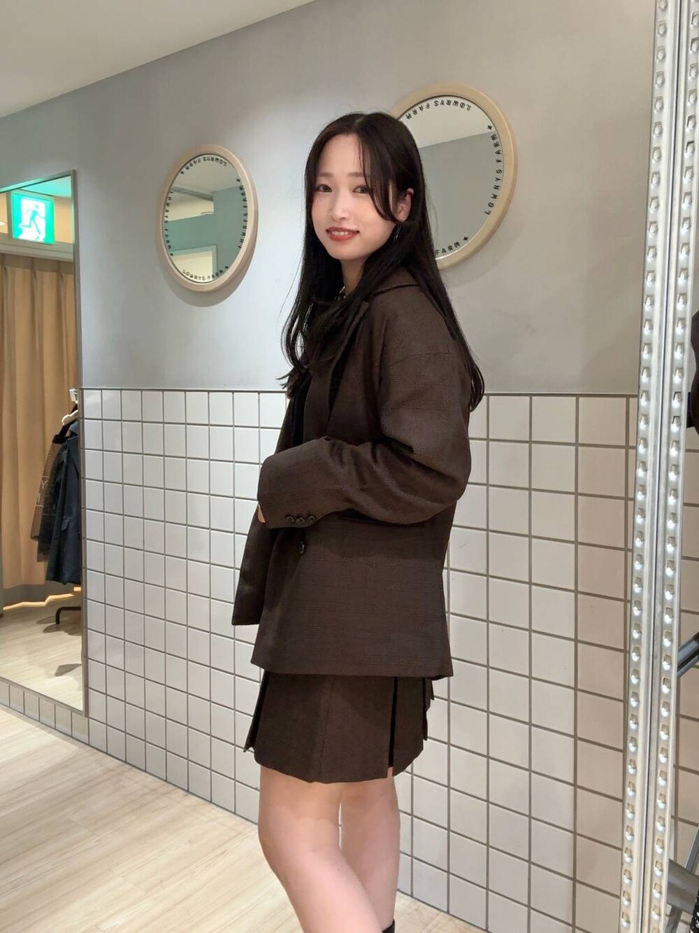 ブラック系のブーツ、ブラウン系のテーラードジャケット、ブラウン系のスカートを着用したレディースの秋コーディネートの3枚目の写真