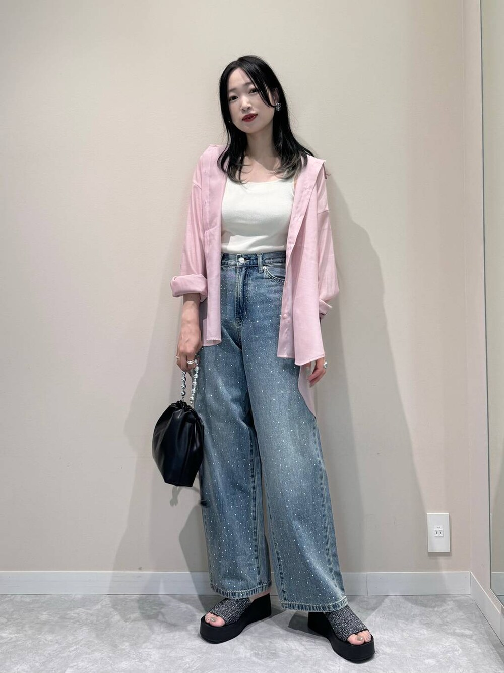 ブラック系のサンダル、ブルー系のデニムパンツ、ホワイト系のタンクトップを着用したレディースの夏コーディネートの4枚目の写真