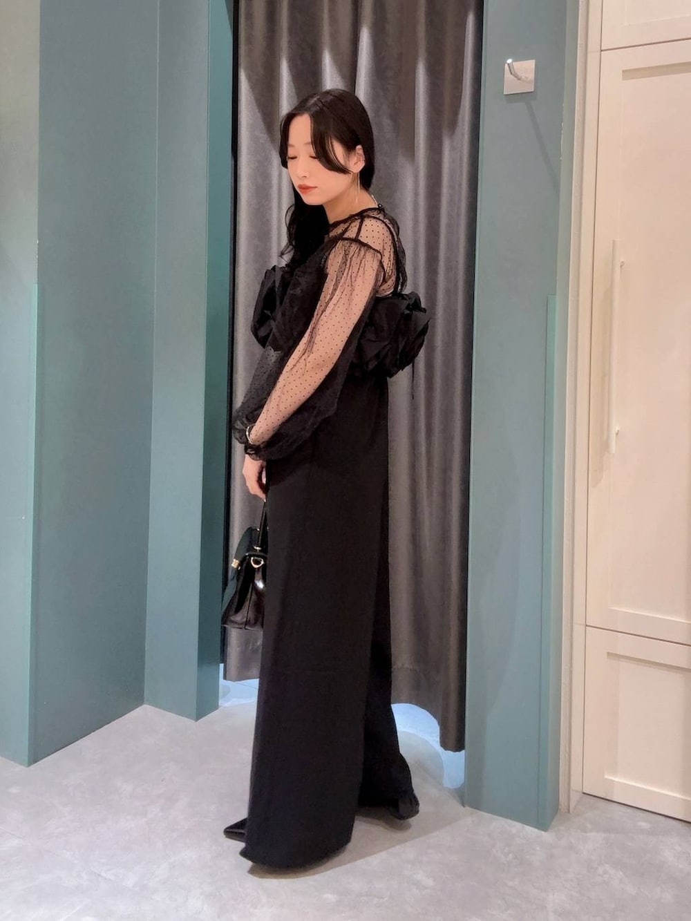 ブラック系のボストンバッグ、ブラック系のワンピース、ブラック系のパンプスを着用したレディースの夏コーディネートの3枚目の写真