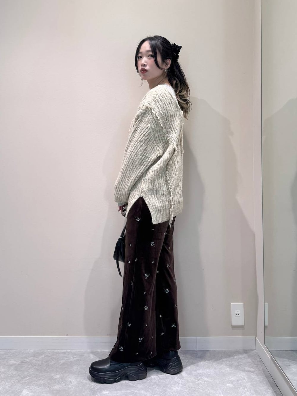 ホワイト系のニット/セーター、ホワイト系のTシャツ/カットソー、ブラック系のショルダーバッグを着用したレディースの冬コーディネートの3枚目の写真